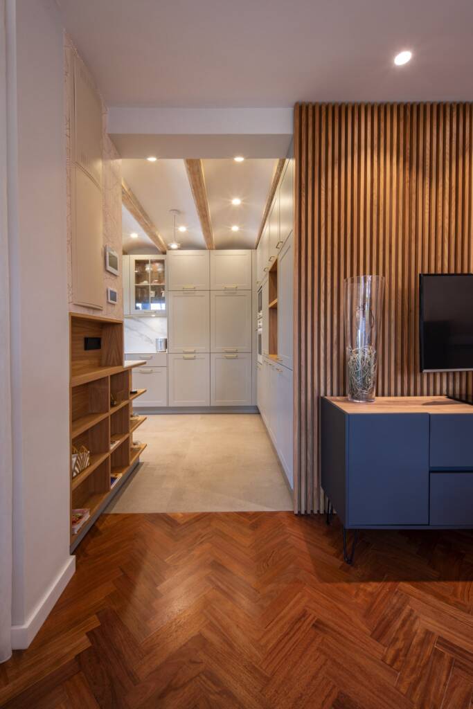 Acceso a cocina que revela vigas vistas de pino, rescatadas y tratadas con laca a juego con la cocina, reflejo del diseño clásico en el interiorismo contemporáneo