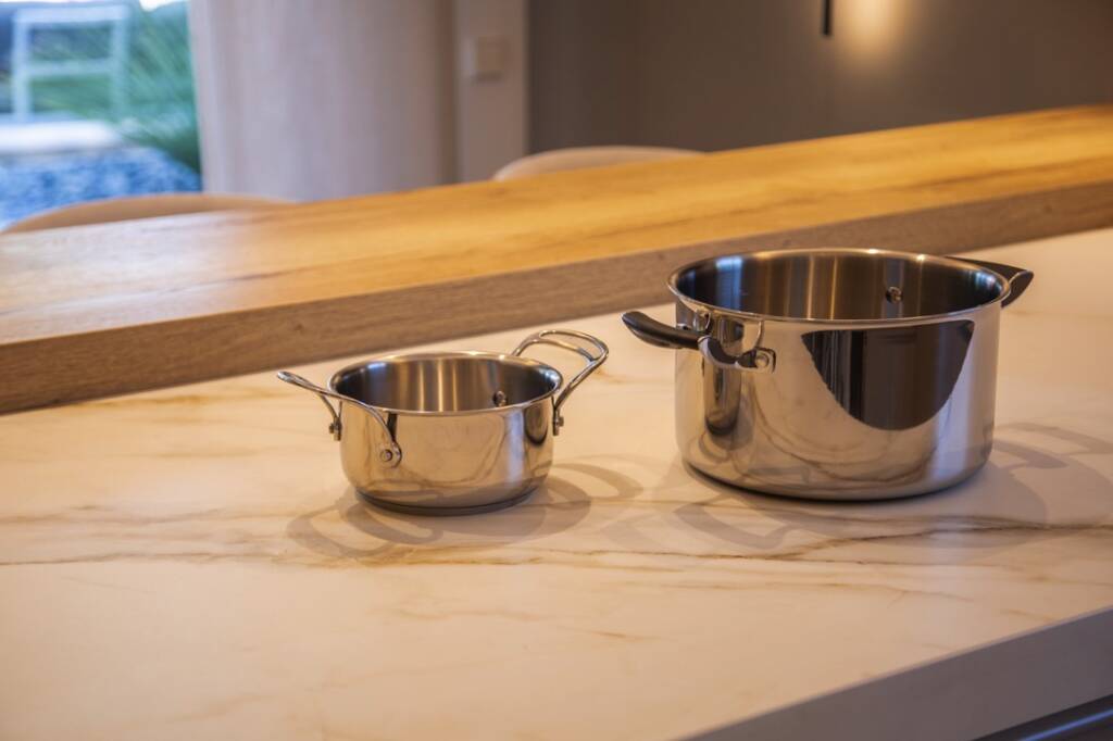 Inducción invisible en de un proyecto Buraglia sobre las que se muestran dos ollas a punto de ser usadas para cocinar