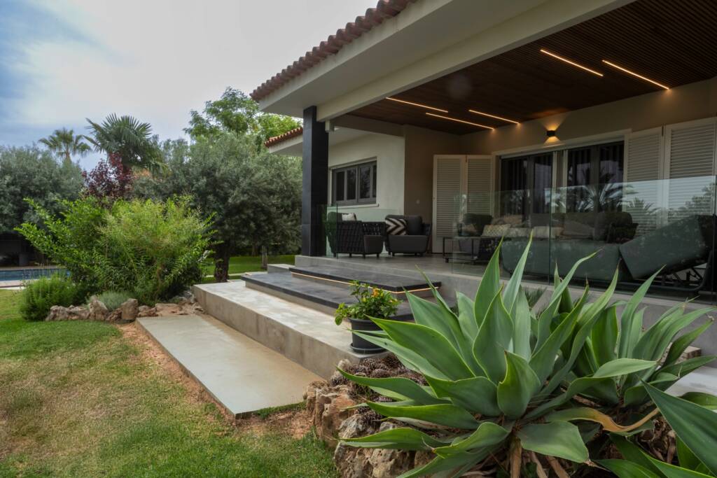 Terraza y jardín integrados en el diseño de interiorismo en Valencia, con pavimento exterior continuo y mobiliario funcional.